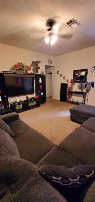 carpeted living room with ceiling fan and visible vents