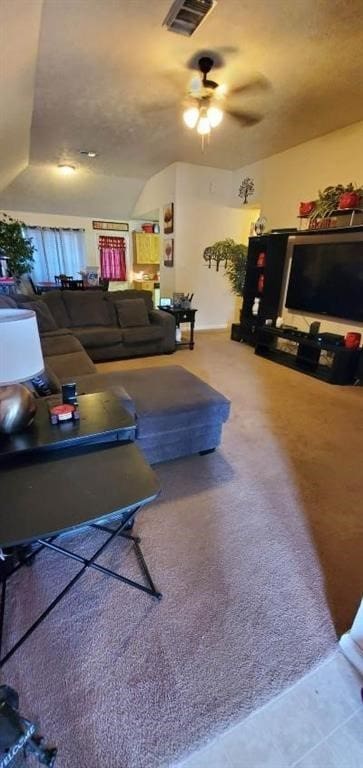 living area featuring tile patterned flooring, carpet flooring, visible vents, and a ceiling fan