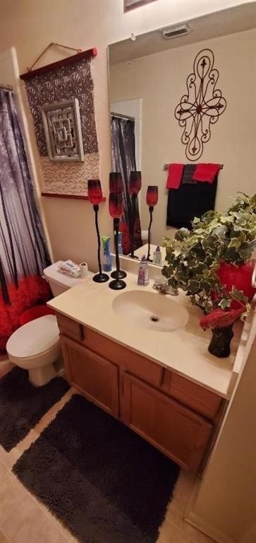 bathroom featuring toilet, visible vents, a shower with shower curtain, and vanity