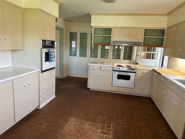 kitchen with ornamental molding, oven, and open shelves