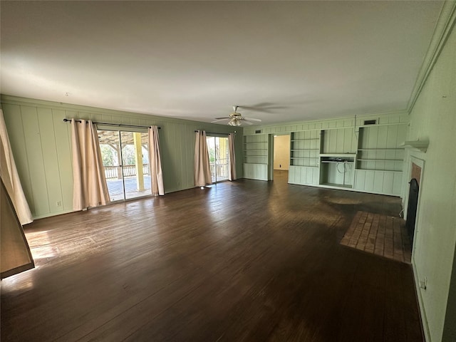 unfurnished living room featuring visible vents, dark wood-type flooring, a fireplace with flush hearth, built in features, and a ceiling fan