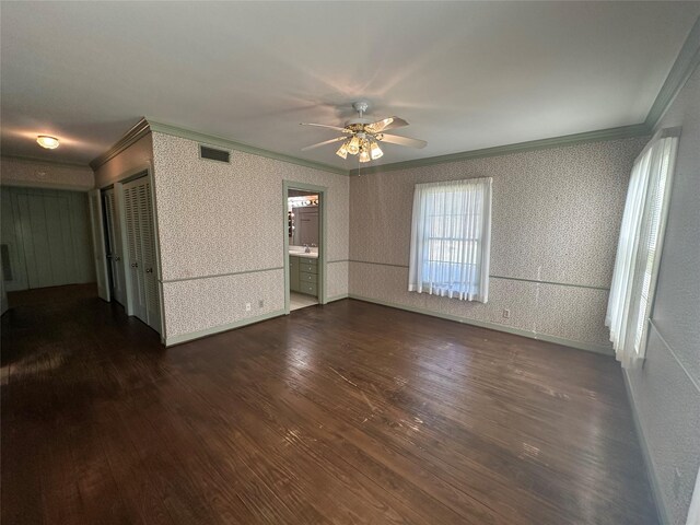 unfurnished room with visible vents, wallpapered walls, crown molding, ceiling fan, and dark wood finished floors