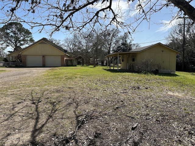 view of yard with a garage, an outdoor structure, and dirt driveway