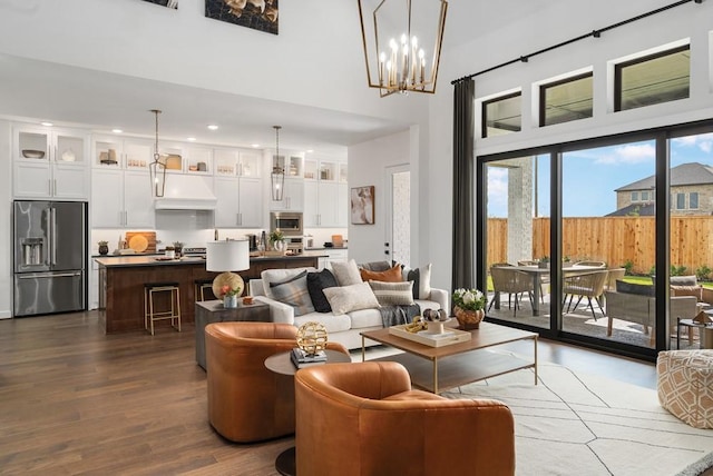 living room with dark wood finished floors, a towering ceiling, and recessed lighting