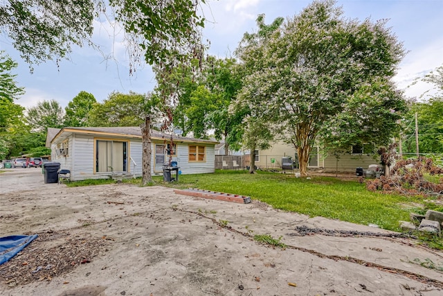 view of front of property featuring a patio area, fence, and a front lawn