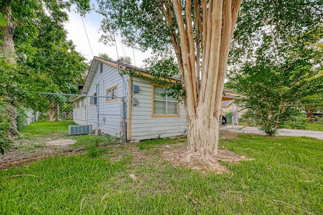 view of side of property with fence and a lawn