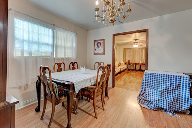 dining area featuring a chandelier, baseboards, and wood finished floors