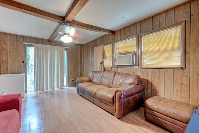 living area with beam ceiling, wood walls, light wood-style flooring, and ceiling fan