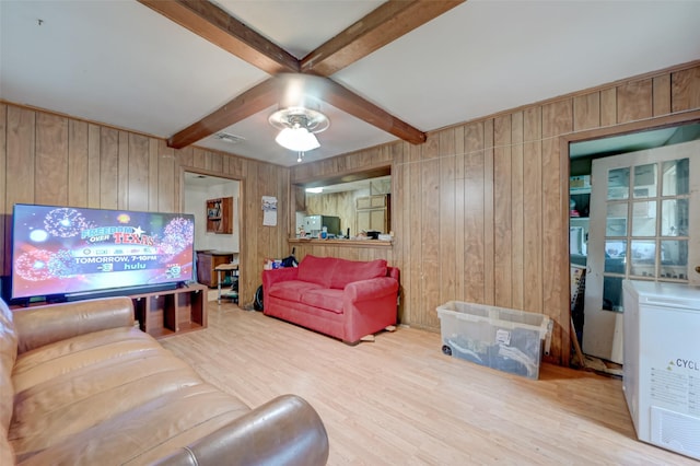 living area featuring visible vents, wood walls, wood finished floors, and beam ceiling