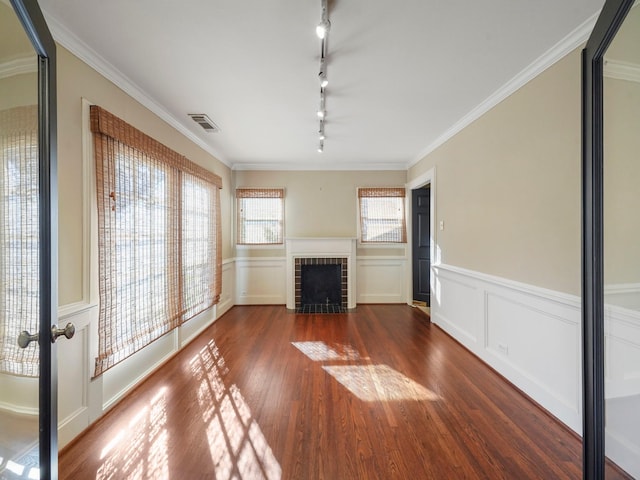 unfurnished living room featuring dark wood-style floors, a brick fireplace, visible vents, and crown molding