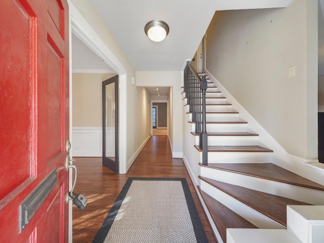 entrance foyer with dark wood-type flooring, stairway, and baseboards