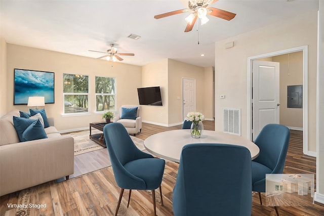 dining room featuring baseboards, visible vents, ceiling fan, and wood finished floors