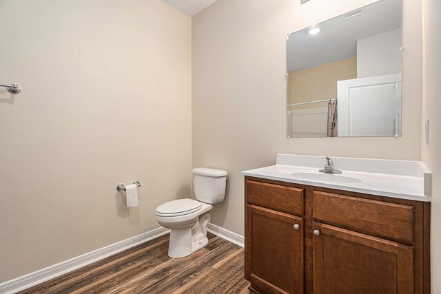 full bathroom featuring baseboards, toilet, wood finished floors, curtained shower, and vanity