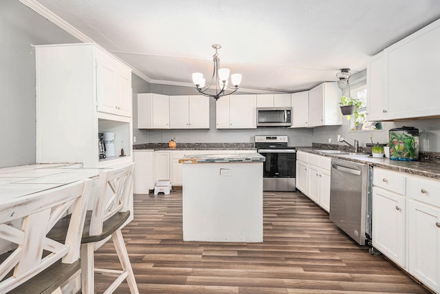 kitchen featuring white cabinets, stainless steel appliances, a sink, and a center island