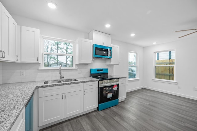 kitchen with light stone counters, dark wood-type flooring, a sink, white cabinetry, and stainless steel electric stove