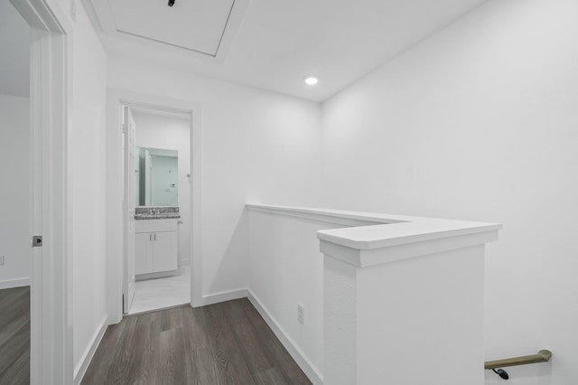 corridor with dark wood-type flooring, recessed lighting, an upstairs landing, and baseboards