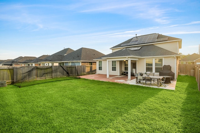 back of house with a fenced backyard, a lawn, and a patio