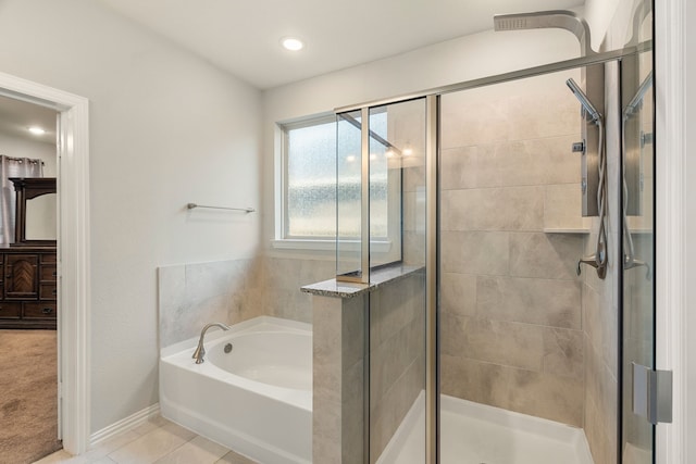 bathroom featuring a bath, tile patterned flooring, a stall shower, and baseboards