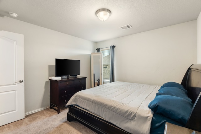 bedroom with light carpet, visible vents, a textured ceiling, and baseboards