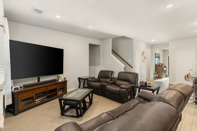 living area featuring visible vents, baseboards, stairs, recessed lighting, and light wood-style flooring