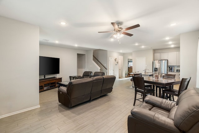 living room with stairway, recessed lighting, light wood-style floors, and ceiling fan