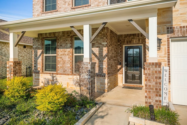 view of exterior entry featuring brick siding and covered porch