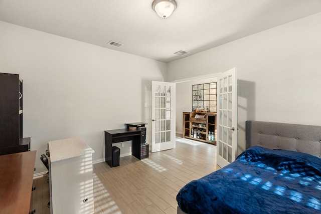 bedroom featuring baseboards, french doors, visible vents, and light wood-type flooring