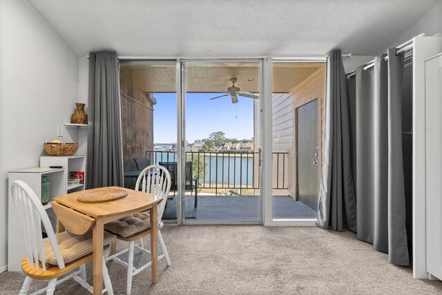 12600 Melville Dr Unit 316B, Montgomery, TX 77356 - carpeted dining space featuring a ceiling fan, floor to ceiling windows, and a water view
