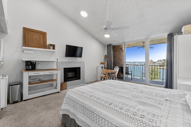 12600 Melville Dr Unit 316B, Montgomery, TX 77356 - carpeted bedroom featuring access to exterior, a fireplace, vaulted ceiling, ceiling fan, and a wall of windows