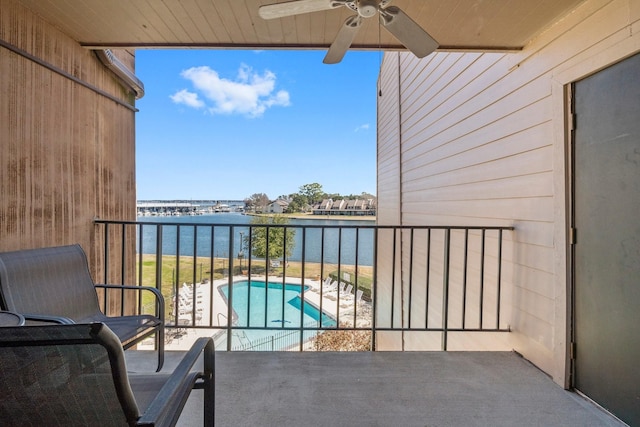 balcony with ceiling fan and a water view