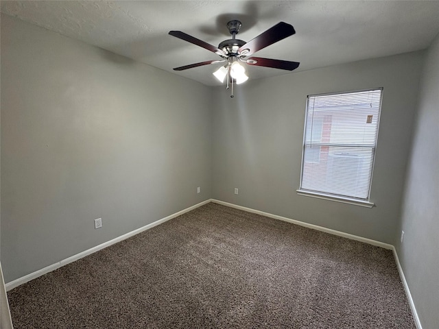 empty room with carpet, ceiling fan, and baseboards