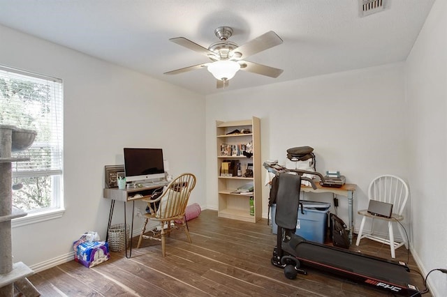 office area with dark wood-style floors, ceiling fan, visible vents, and baseboards