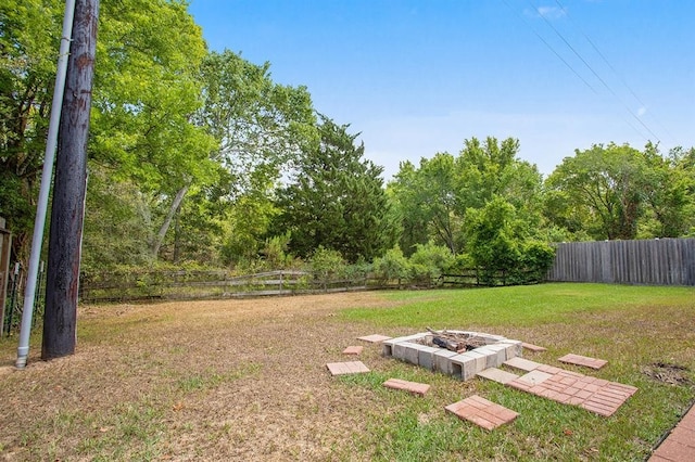 view of yard featuring an outdoor fire pit and a fenced backyard