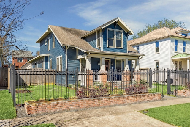 view of front of home with a shingled roof, a fenced front yard, and a front yard