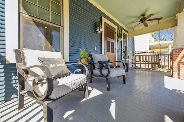 wooden deck with a porch and a ceiling fan