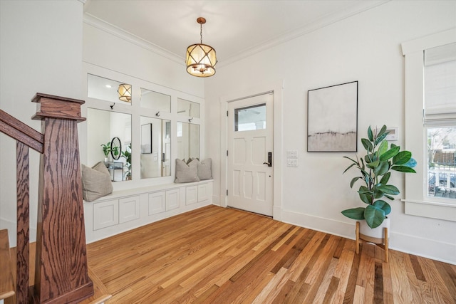 entrance foyer featuring light wood-style flooring, baseboards, and crown molding