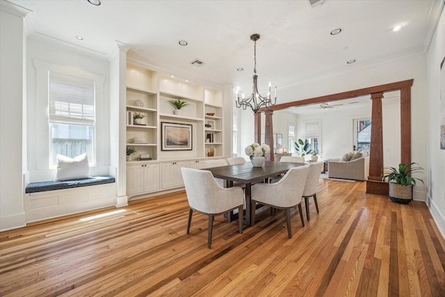 dining area featuring ornamental molding, light wood-type flooring, baseboards, and built in features