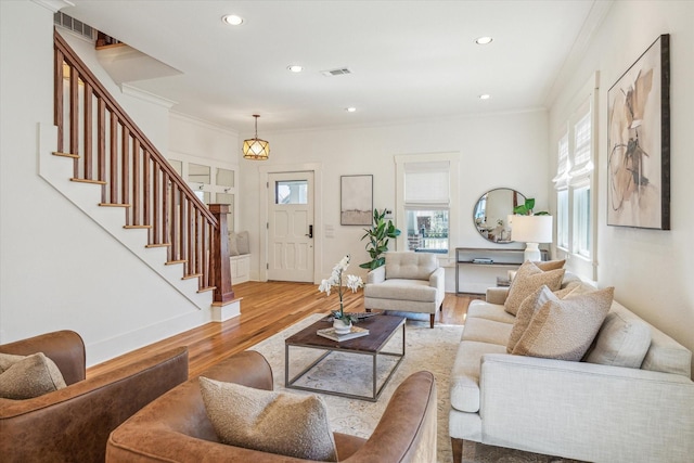 living area featuring recessed lighting, visible vents, stairway, ornamental molding, and wood finished floors