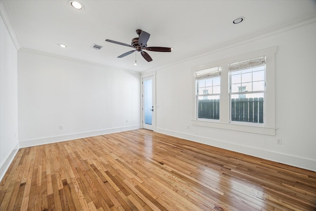 spare room featuring light wood-style floors, baseboards, visible vents, and ornamental molding