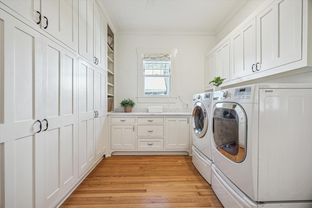 laundry area with light wood-type flooring, cabinet space, crown molding, and separate washer and dryer