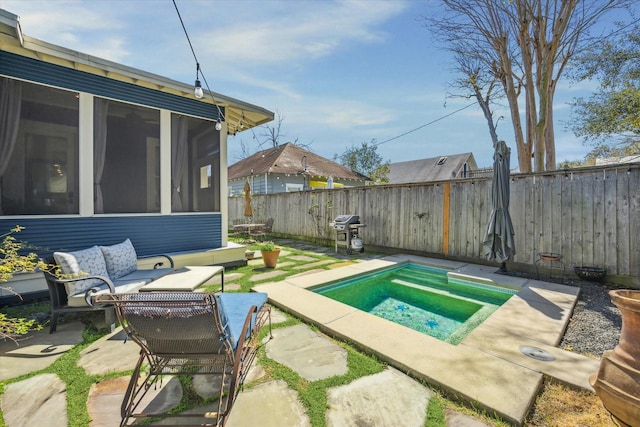 view of pool featuring outdoor lounge area, a sunroom, a patio area, a grill, and a fenced backyard