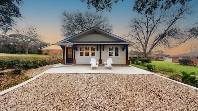 view of front of home featuring a patio area and a yard