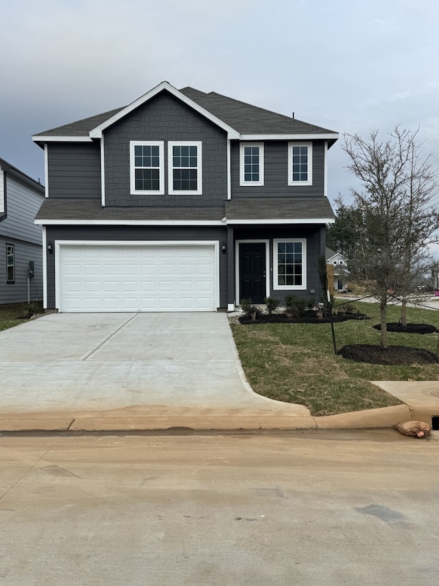 traditional-style home with driveway, an attached garage, and a front lawn