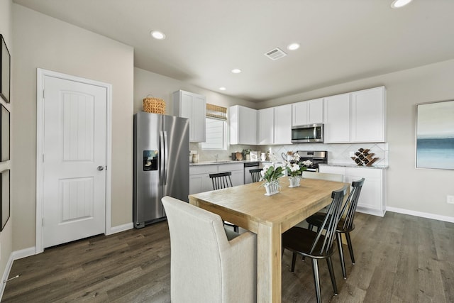 kitchen featuring appliances with stainless steel finishes, light countertops, white cabinetry, and tasteful backsplash