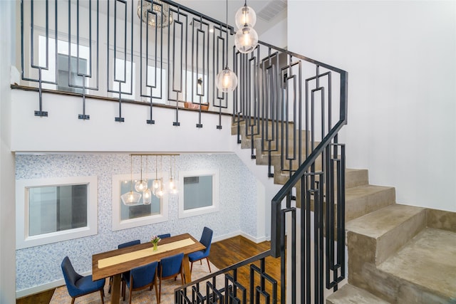 1016 Crocker St, Houston, TX 77019 - stairs featuring wallpapered walls, baseboards, visible vents, a towering ceiling, and wood finished floors