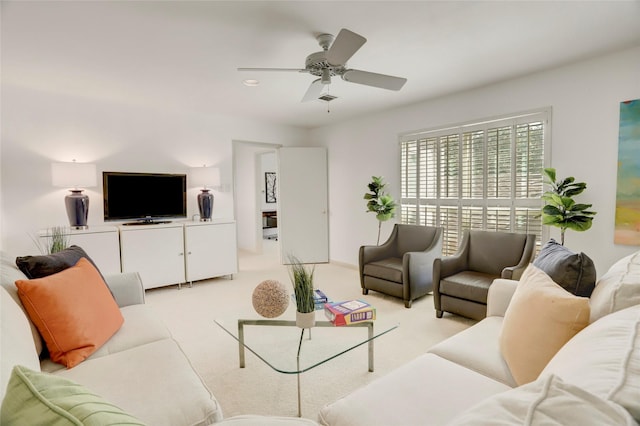 living area with light carpet and ceiling fan