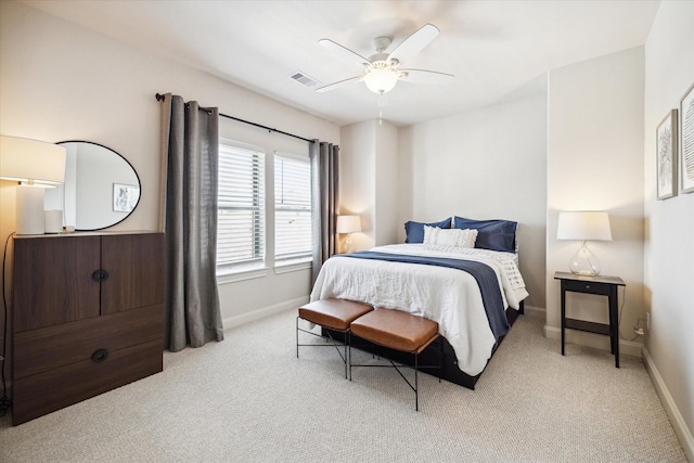 bedroom with a ceiling fan, light colored carpet, visible vents, and baseboards