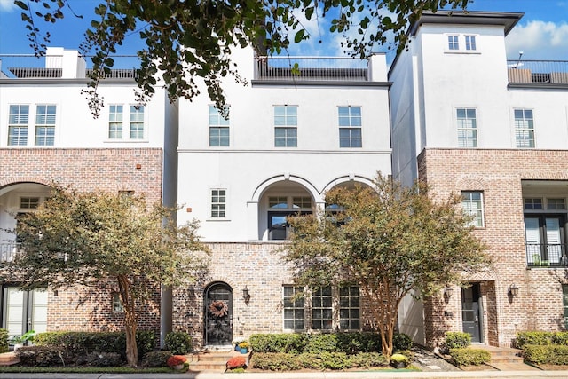 view of front of property with brick siding and stucco siding