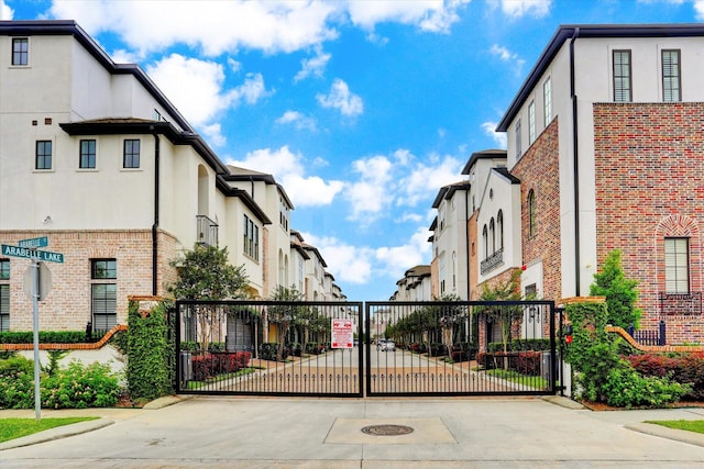 view of street featuring a residential view, a gate, curbs, and a gated entry