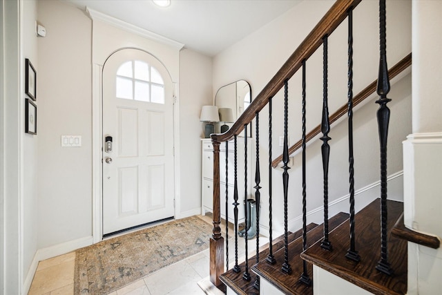 foyer with baseboards and stairs